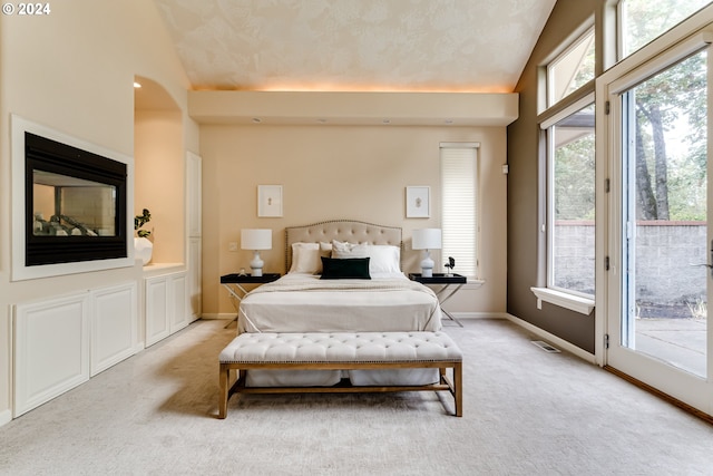 bedroom featuring lofted ceiling, access to exterior, light carpet, and baseboards