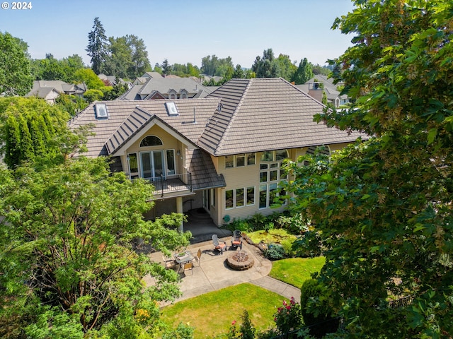 exterior space with a yard, a tile roof, a fire pit, and a patio