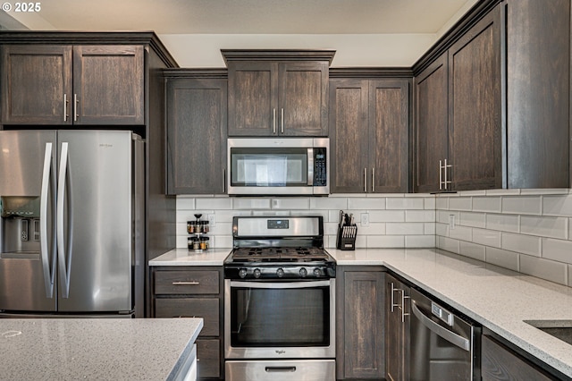 kitchen with decorative backsplash, dark brown cabinetry, stainless steel appliances, and light stone countertops