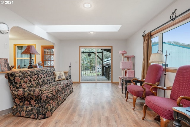 sitting room featuring a skylight and light hardwood / wood-style floors