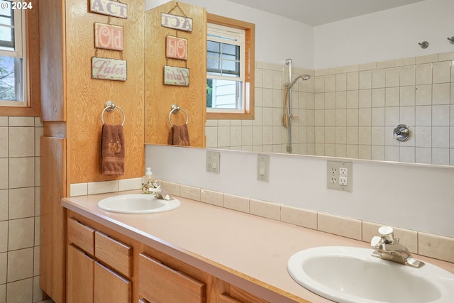 bathroom with vanity, tiled shower, and a wealth of natural light