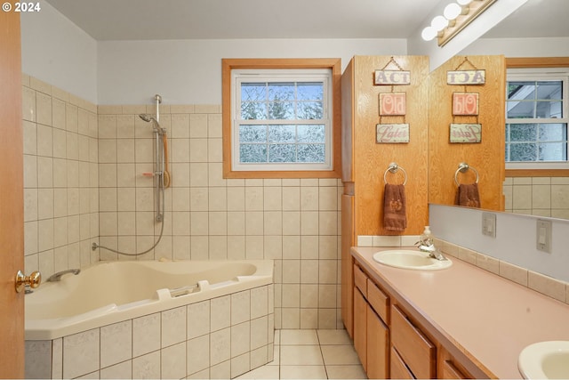 bathroom with tile patterned flooring, vanity, and tiled shower / bath