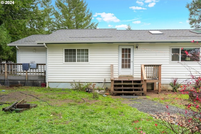 rear view of property featuring a lawn