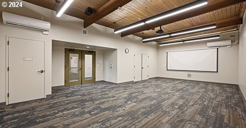 unfurnished room featuring a wall mounted air conditioner, french doors, beamed ceiling, dark hardwood / wood-style flooring, and wood ceiling