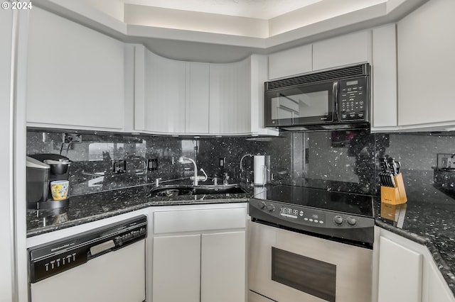 kitchen featuring dark stone counters, dishwashing machine, stainless steel electric range oven, sink, and white cabinetry