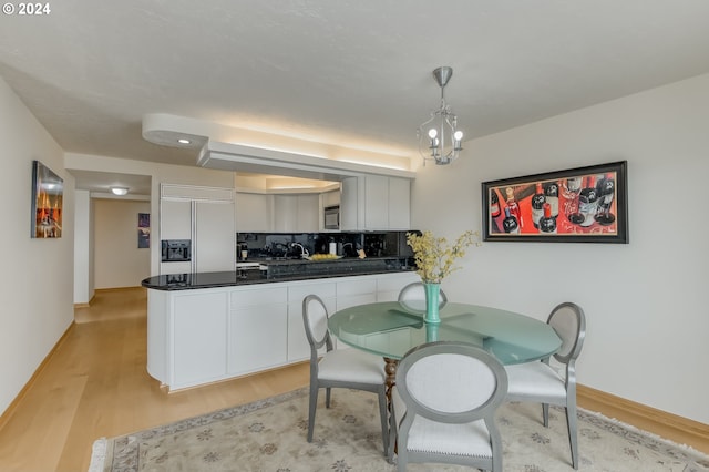 dining area with a chandelier and light hardwood / wood-style floors