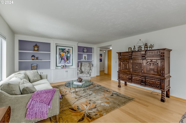 living room with built in shelves and wood-type flooring