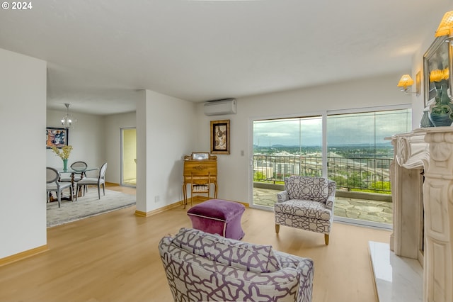 living area with an AC wall unit, hardwood / wood-style floors, and a notable chandelier