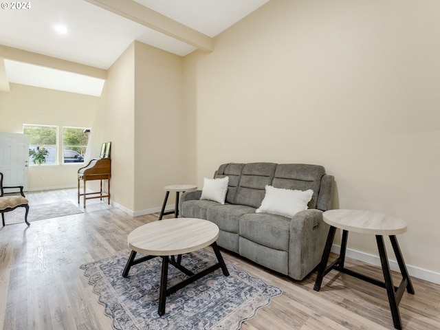 living room with beam ceiling, baseboards, and wood finished floors