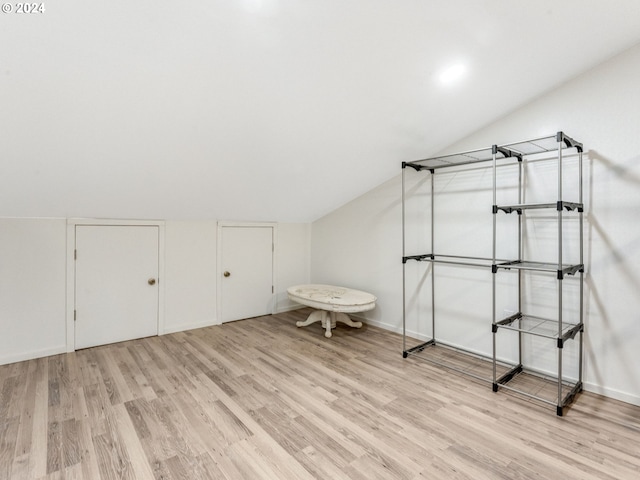 bonus room with lofted ceiling, light wood-style floors, and baseboards