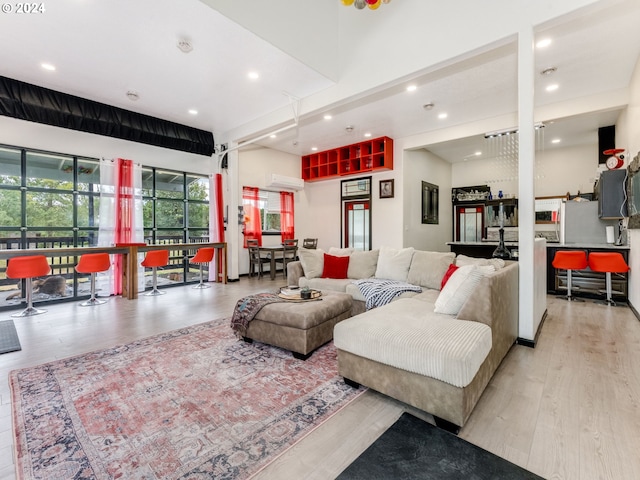 living room featuring recessed lighting, wood finished floors, and a wall mounted AC