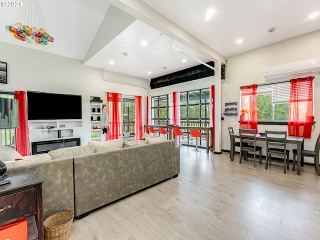 living area featuring a healthy amount of sunlight, a wall unit AC, and wood finished floors