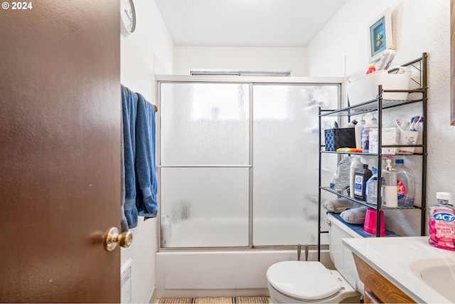 full bathroom featuring shower / bath combination with glass door, vanity, toilet, and tile patterned floors