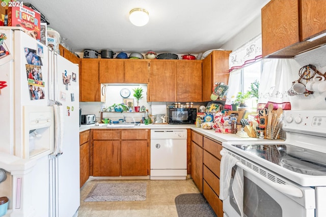 kitchen featuring white appliances, light tile patterned floors, and sink