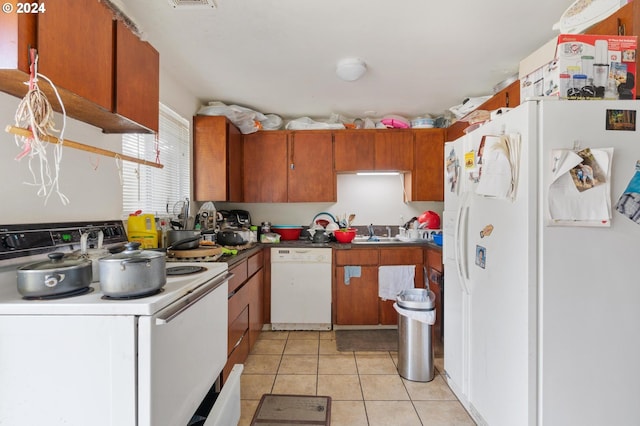 kitchen with white appliances, light tile patterned flooring, and sink