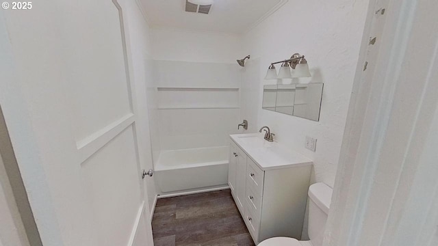 bathroom with toilet, vanity, shower / bathtub combination, wood finished floors, and visible vents