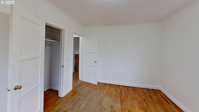 unfurnished bedroom featuring baseboards, ornamental molding, a closet, and light wood-type flooring