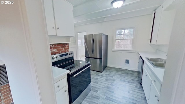 kitchen featuring white cabinets, visible vents, light wood finished floors, stainless steel appliances, and a sink