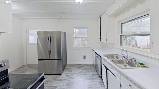 kitchen with light countertops, visible vents, stainless steel appliances, white cabinetry, and a sink