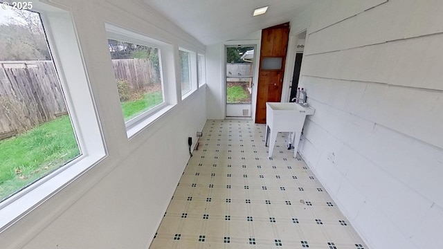 hallway featuring vaulted ceiling and sink