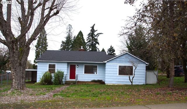 ranch-style house featuring a chimney, a shingled roof, and entry steps