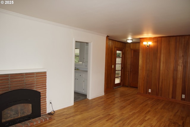 unfurnished living room with a fireplace, hardwood / wood-style floors, and crown molding