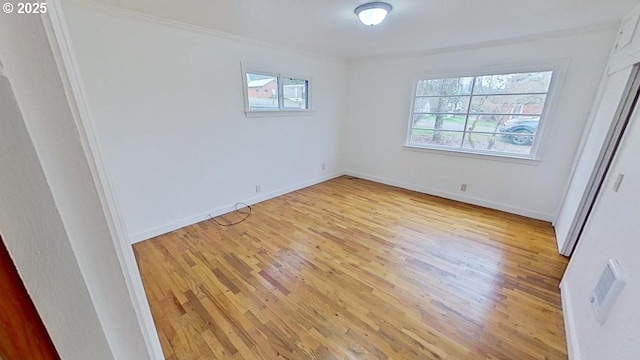 unfurnished bedroom with ornamental molding, baseboards, and light wood finished floors