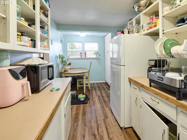 kitchen featuring white refrigerator, white cabinetry, and light wood-type flooring