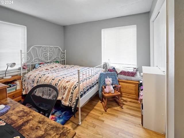 bedroom with multiple windows and light wood-type flooring