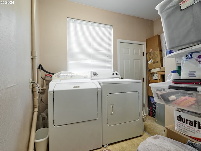 clothes washing area with washer and dryer and light tile floors