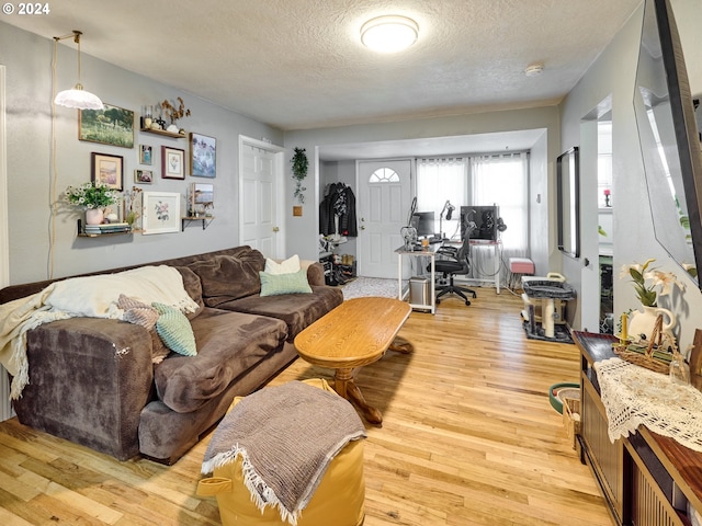 living room with a textured ceiling and light wood-type flooring