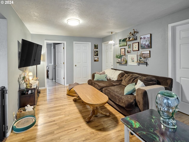 living room featuring light hardwood / wood-style flooring and a textured ceiling