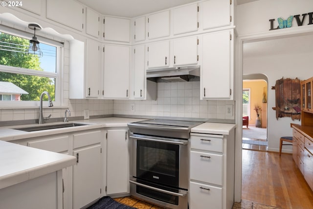 kitchen with decorative backsplash, light hardwood / wood-style flooring, sink, electric range, and white cabinets