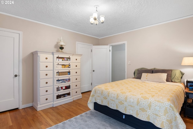 bedroom with wood-type flooring, a textured ceiling, and a chandelier