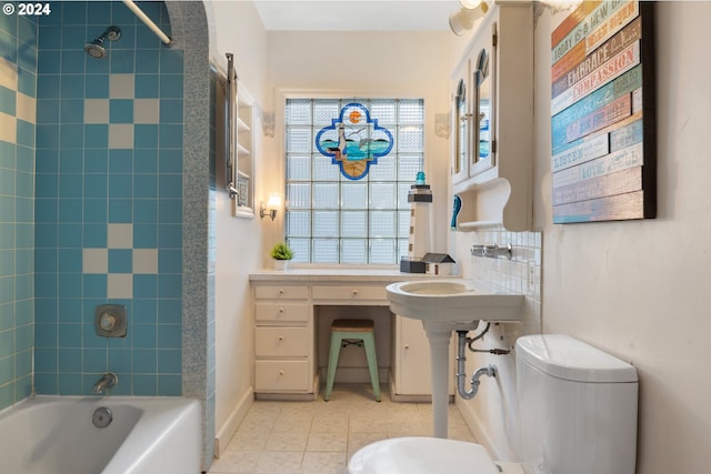 bathroom with toilet, tile patterned flooring, and tiled shower / bath