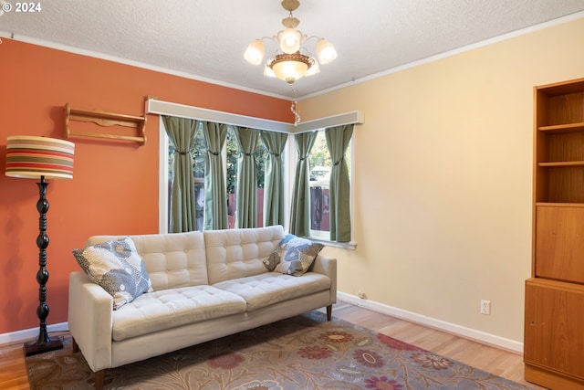 living room with crown molding, a textured ceiling, hardwood / wood-style flooring, and an inviting chandelier