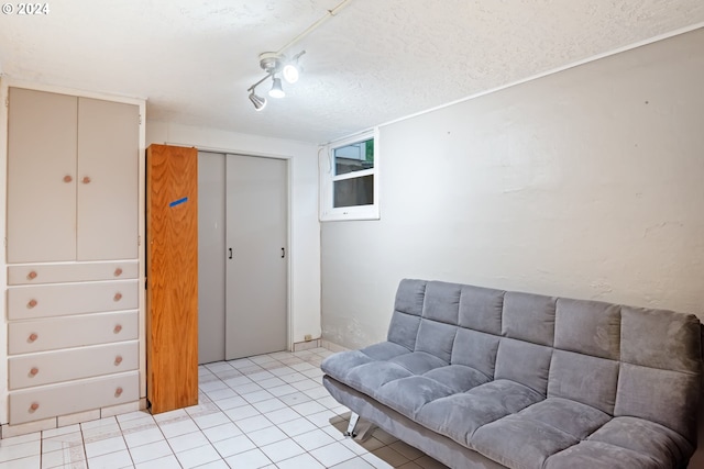 sitting room with a textured ceiling and light tile patterned flooring