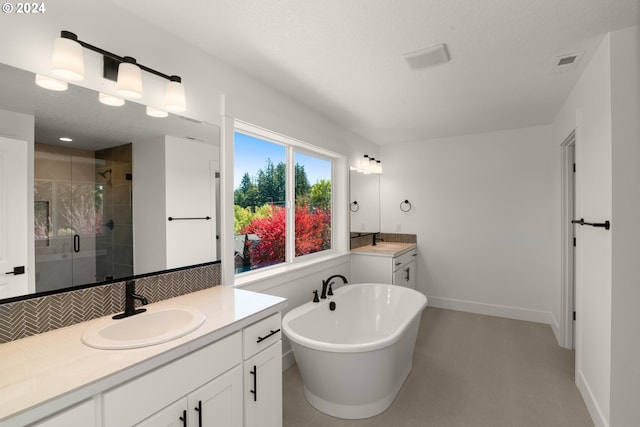 bathroom with separate shower and tub, vanity, and a textured ceiling