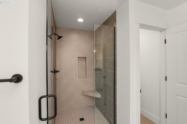 bathroom with an enclosed shower and a textured ceiling