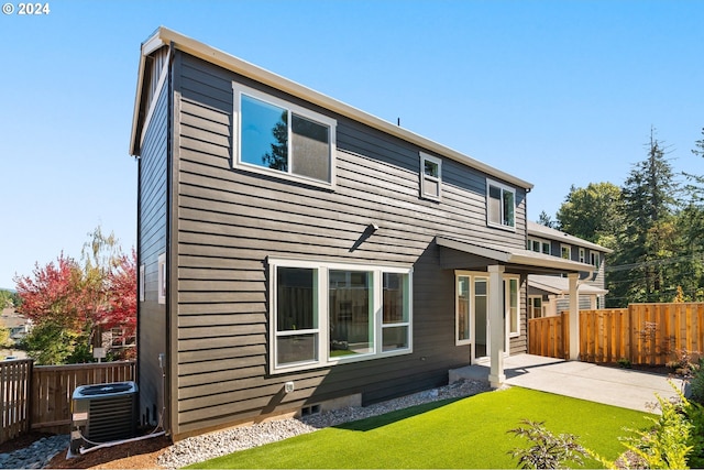 rear view of property with a patio area, a yard, and central air condition unit