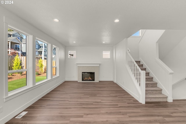 unfurnished living room with a textured ceiling and light wood-type flooring