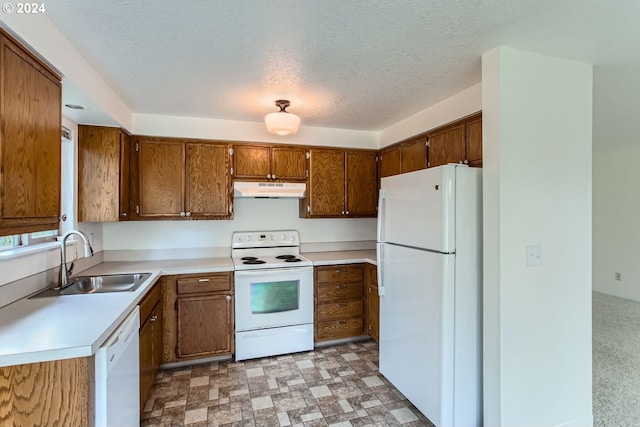 kitchen with a textured ceiling, white appliances, and sink