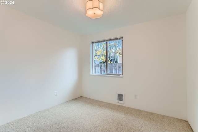 carpeted empty room featuring a textured ceiling