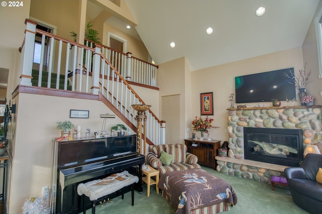 carpeted living room with a fireplace and high vaulted ceiling