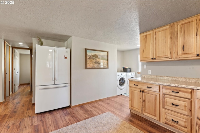 17943 Old Auburn Ln, Baker City, OR 97814 - kitchen featuring freestanding refrigerator, light brown cabinets, washer and clothes dryer, a textured ceiling, and light wood-style floors