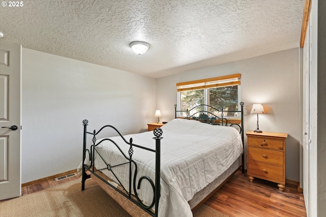 17943 Old Auburn Ln, Baker City, OR 97814 - bedroom with wood finished floors, a textured ceiling, and baseboards