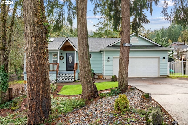 ranch-style home featuring fence, covered porch, concrete driveway, a shingled roof, and a garage