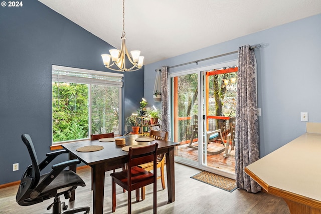 dining area featuring lofted ceiling, an inviting chandelier, and wood finished floors