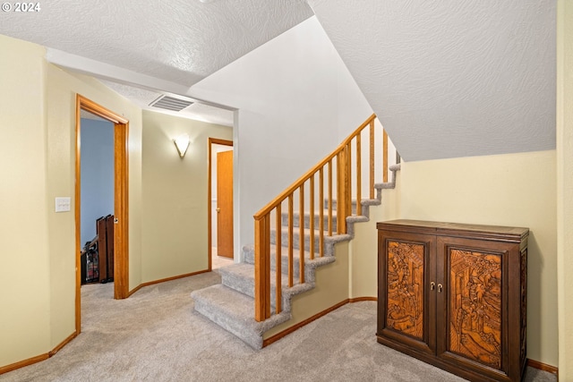 stairway featuring visible vents, carpet flooring, and baseboards