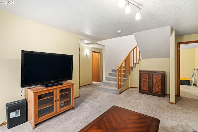 living room featuring stairway, visible vents, carpet floors, and a textured ceiling